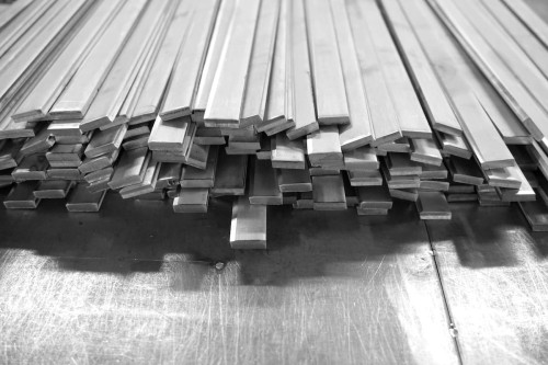 Stalowe płaskowniki 15 x 10 mm ułożone w stos. Idealne do konstrukcji i projektów stalowych