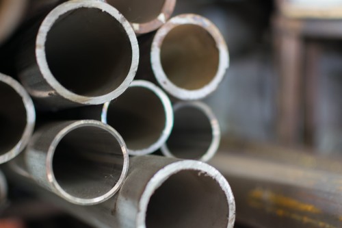 Metalowe rury stalowe ze szwem o różnych średnicach i długościach ułożone w stos